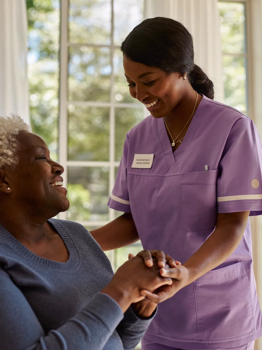 A Faithful Servants caregiver assisting a smiling elderly client at home
